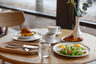 Photo of Delicious breakfast served on wooden table in cafe