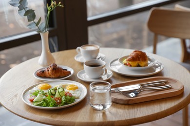 Photo of Delicious breakfast served on wooden table in cafe