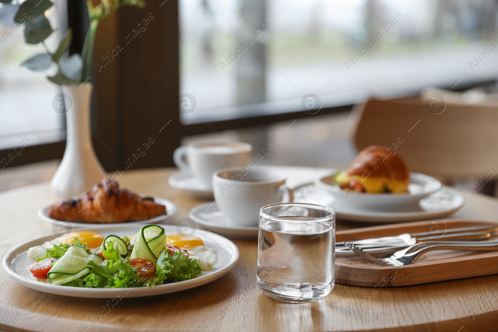 Photo of Delicious breakfast served on wooden table in cafe