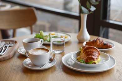 Photo of Delicious breakfast served on wooden table in cafe