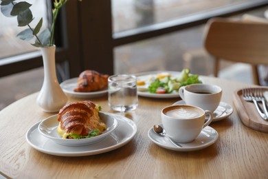 Photo of Delicious breakfast served on wooden table in cafe