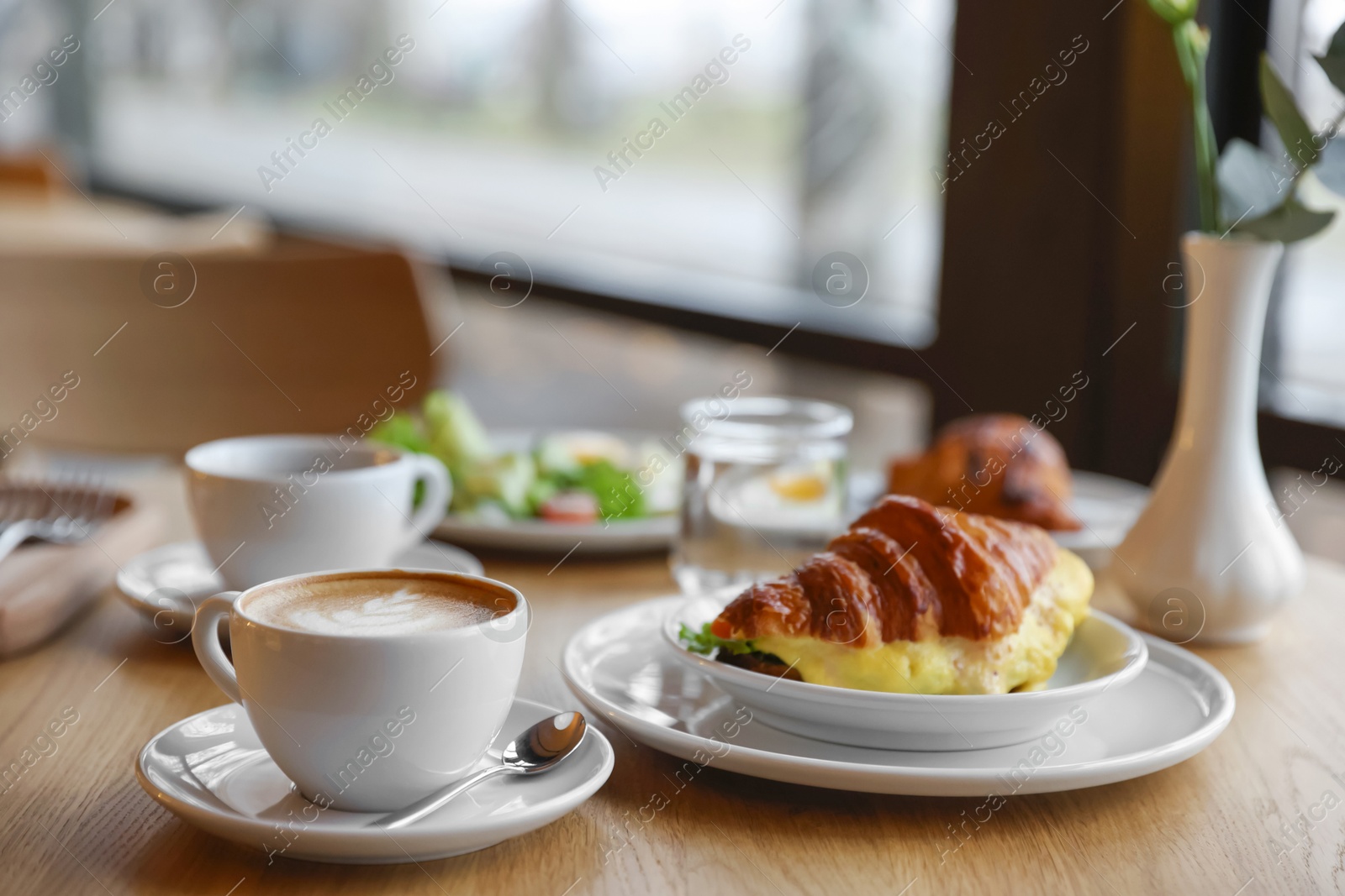 Photo of Delicious breakfast served on wooden table in cafe