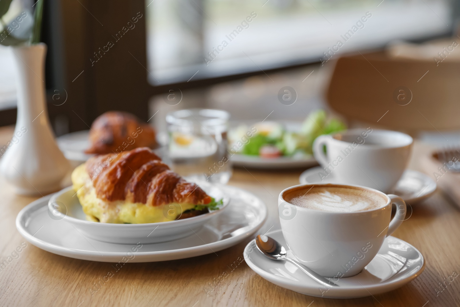 Photo of Delicious breakfast served on wooden table in cafe