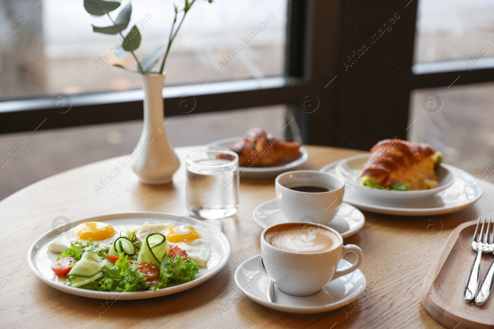 Photo of Delicious breakfast served on wooden table in cafe