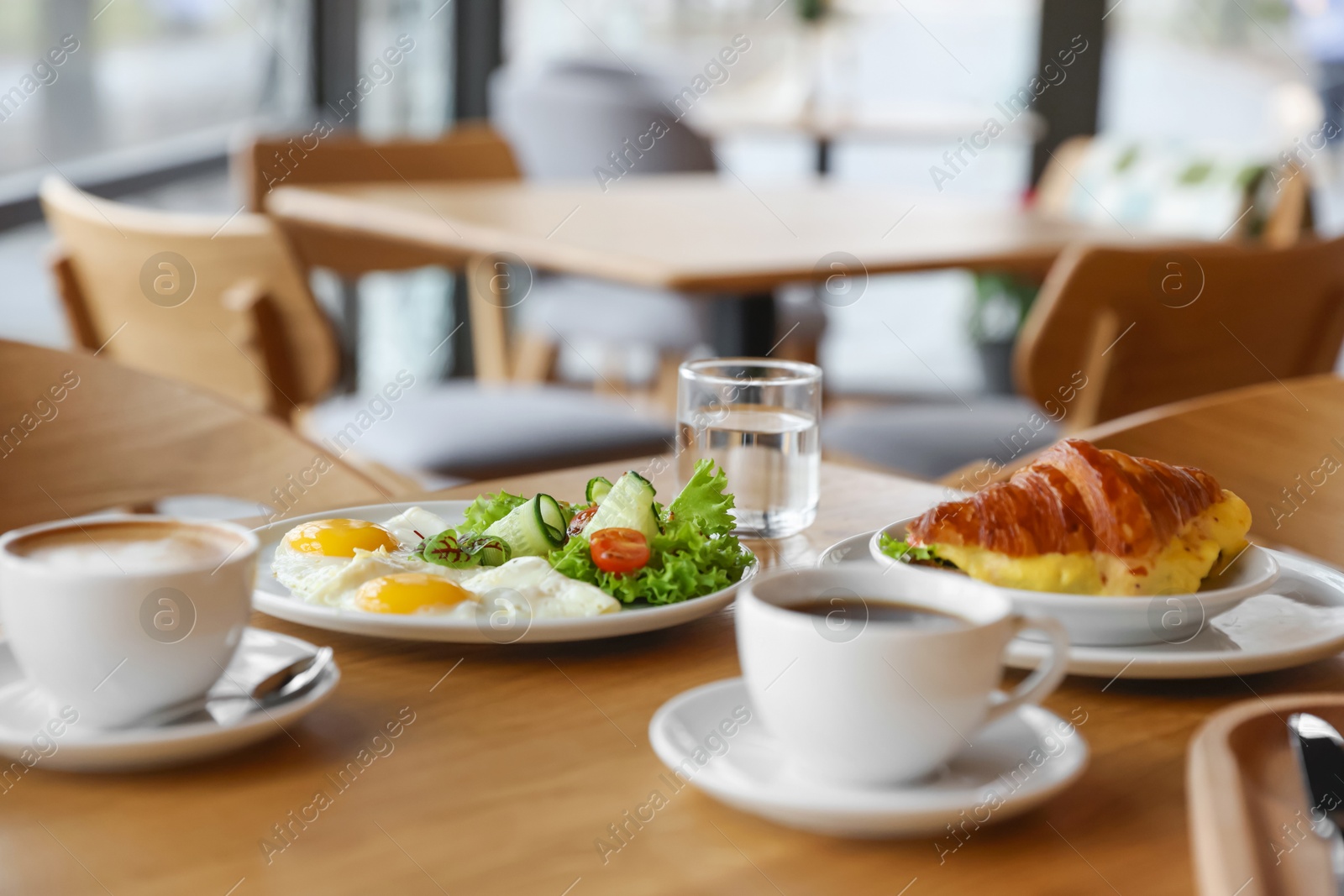 Photo of Delicious breakfast served on wooden table in cafe