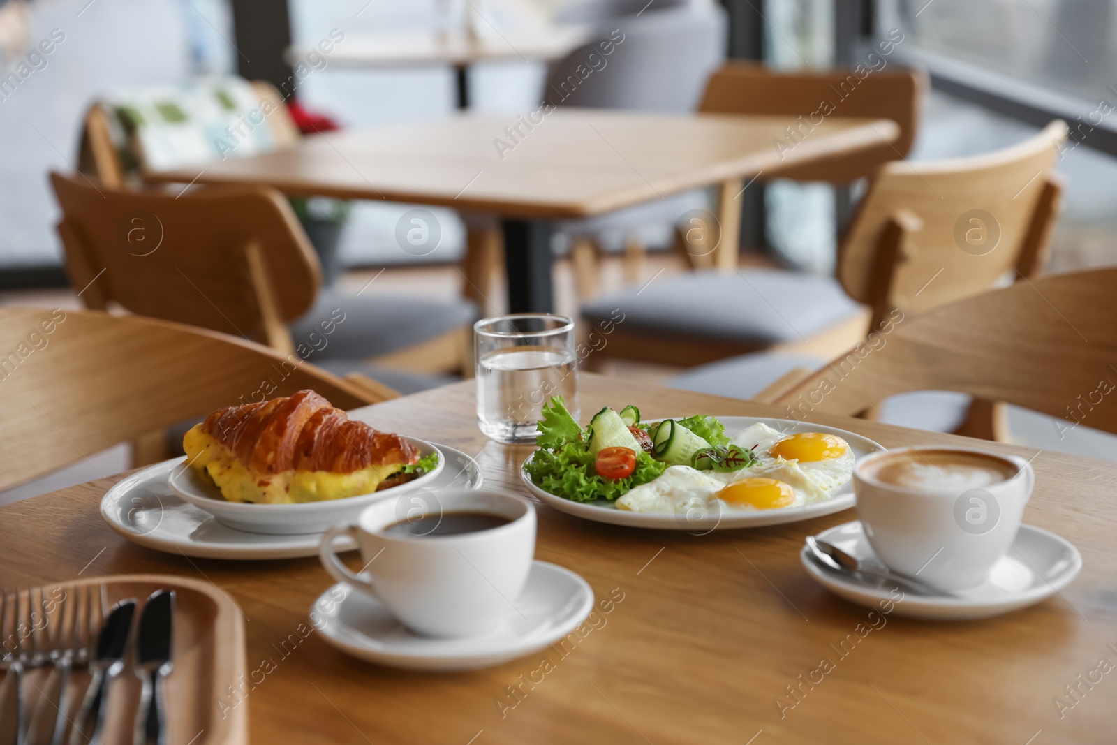 Photo of Delicious breakfast served on wooden table in cafe