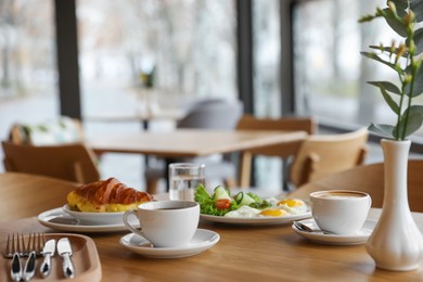 Photo of Delicious breakfast served on wooden table in cafe