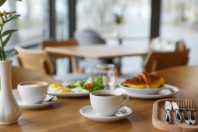 Photo of Delicious breakfast served on wooden table in cafe