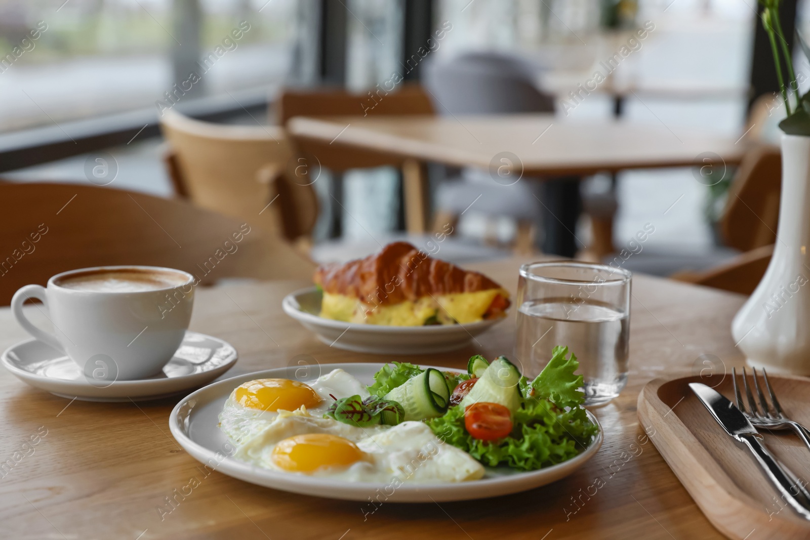 Photo of Delicious breakfast served on wooden table in cafe