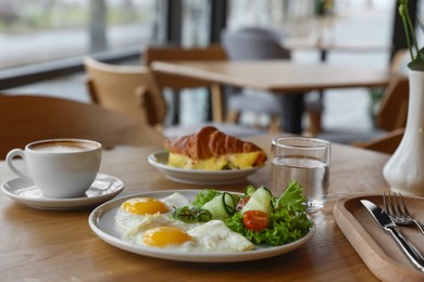 Photo of Delicious breakfast served on wooden table in cafe