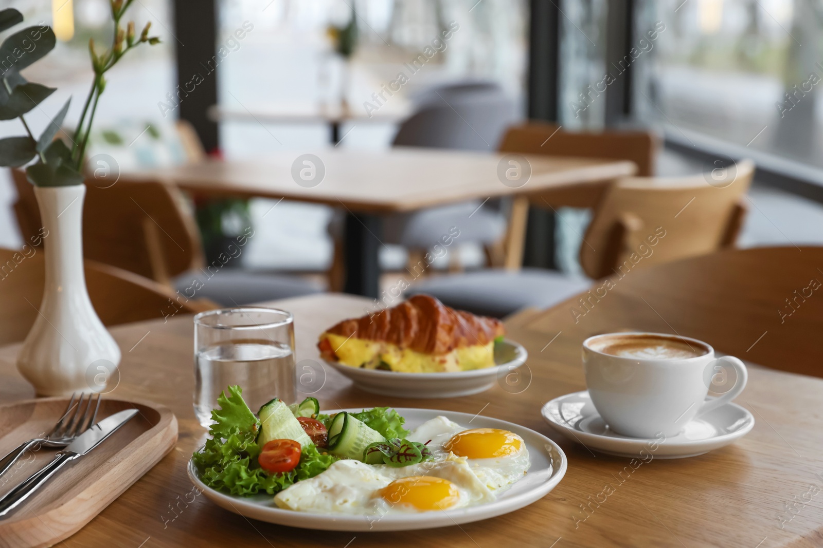 Photo of Delicious breakfast served on wooden table in cafe