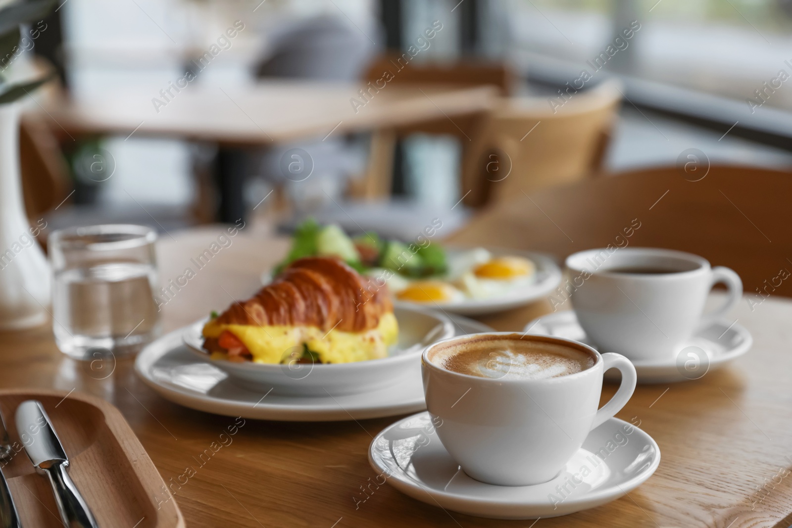 Photo of Delicious breakfast served on wooden table in cafe