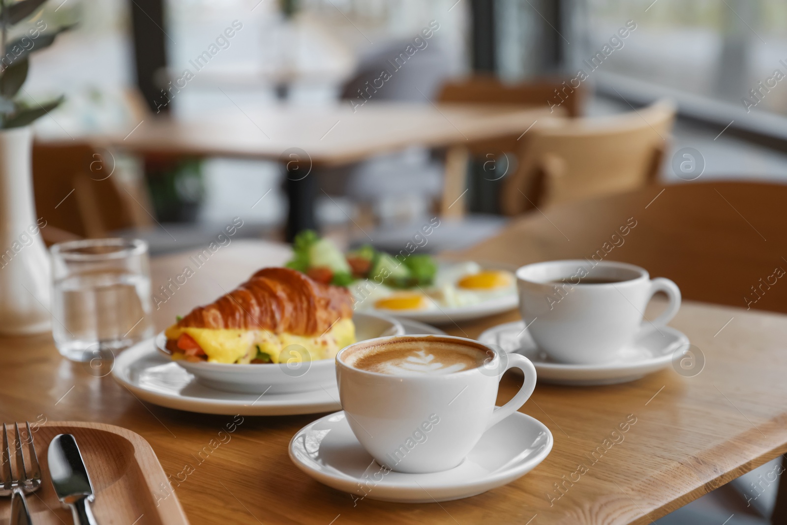 Photo of Delicious breakfast served on wooden table in cafe