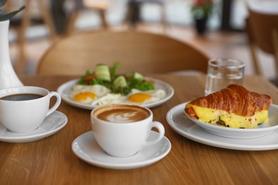 Photo of Delicious breakfast served on wooden table in cafe