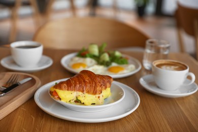 Photo of Delicious breakfast served on wooden table in cafe