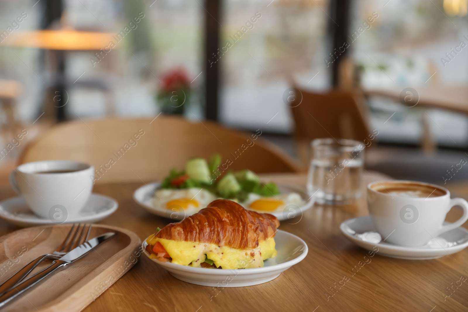 Photo of Delicious breakfast served on wooden table in cafe