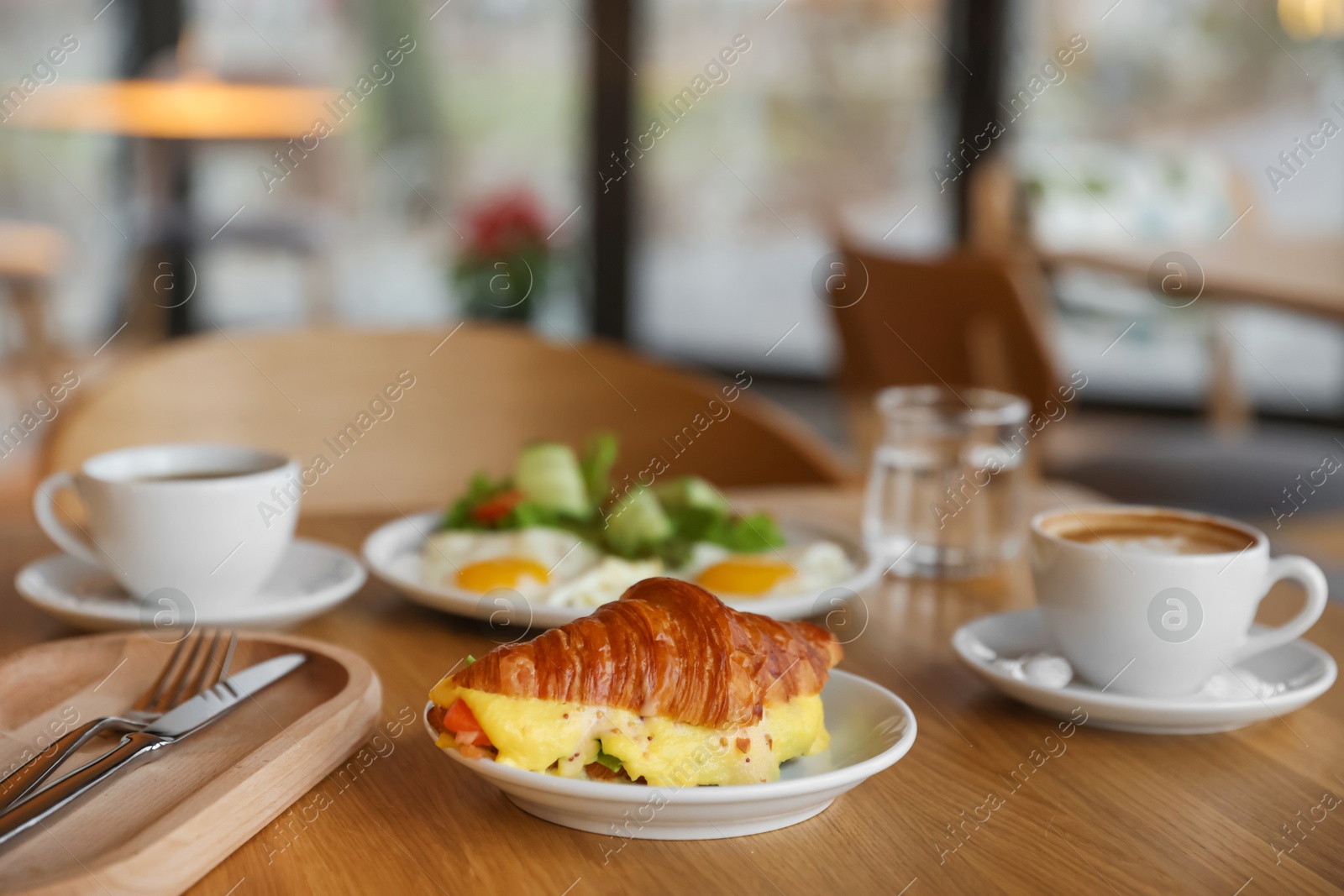 Photo of Delicious breakfast served on wooden table in cafe