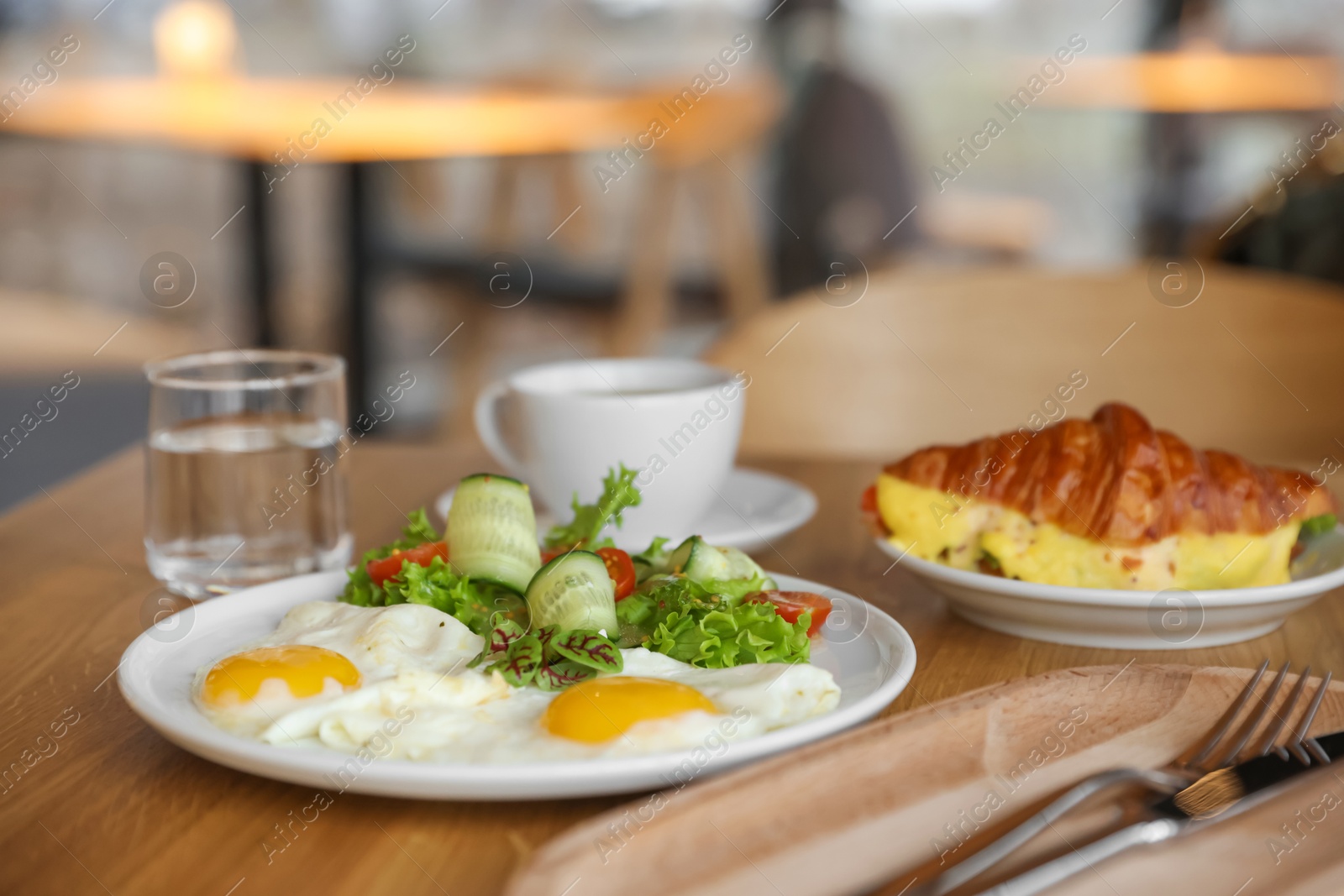 Photo of Delicious breakfast served on wooden table in cafe