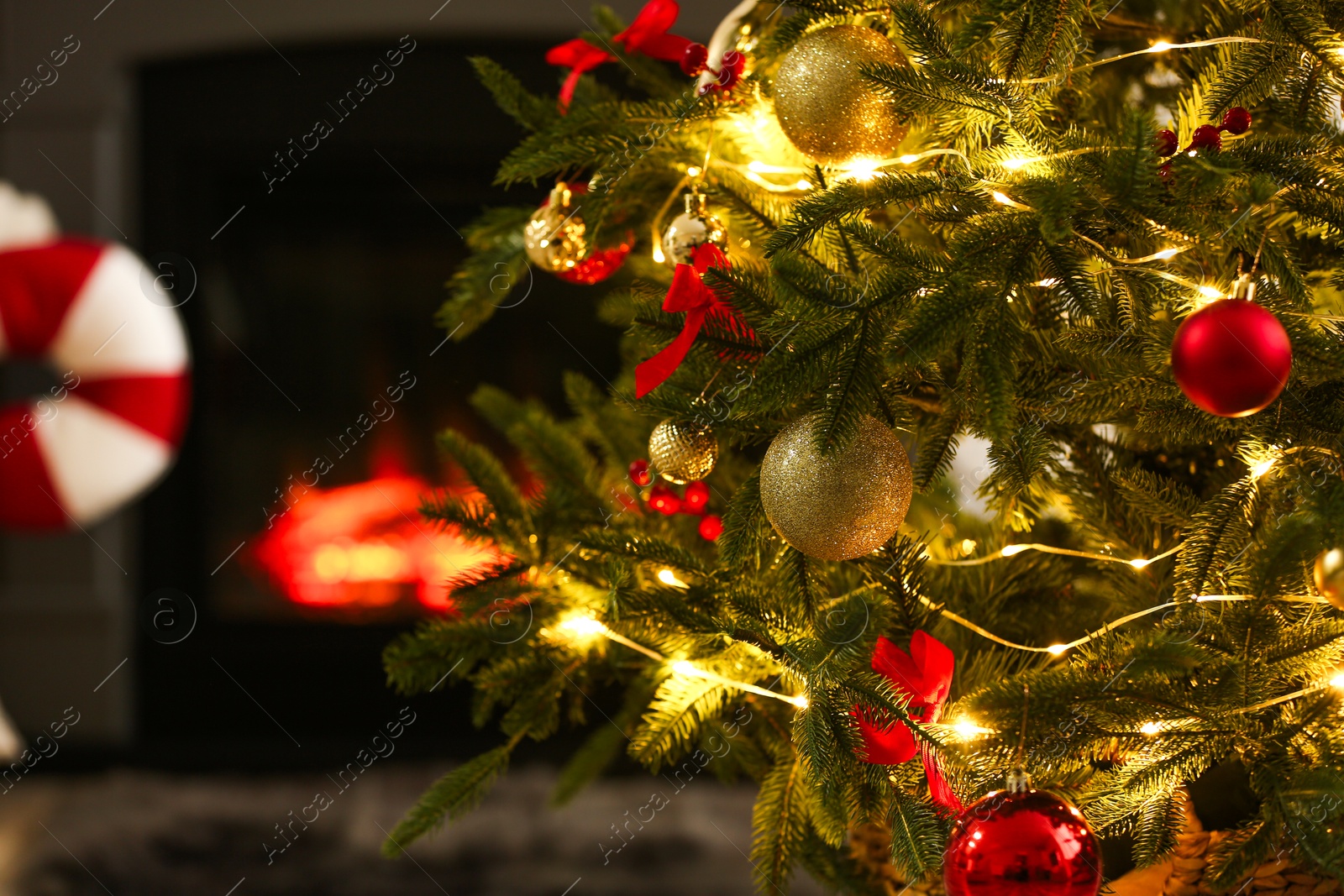 Photo of Beautiful decorated Christmas tree near fireplace at home, closeup. Space for text