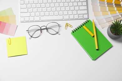 Photo of Designer's workplace with keyboard and stationery on light background, flat lay. Space for text