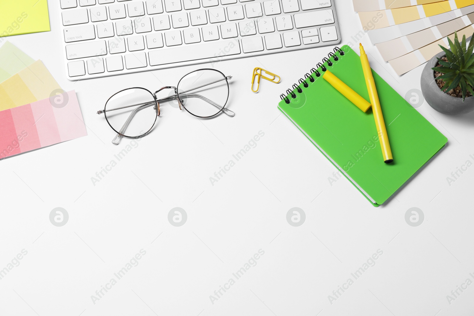 Photo of Designer's workplace with keyboard and stationery on light background, flat lay. Space for text