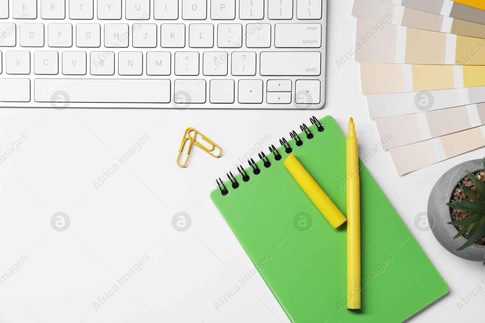 Photo of Designer's workplace with keyboard and stationery on light background, flat lay. Space for text