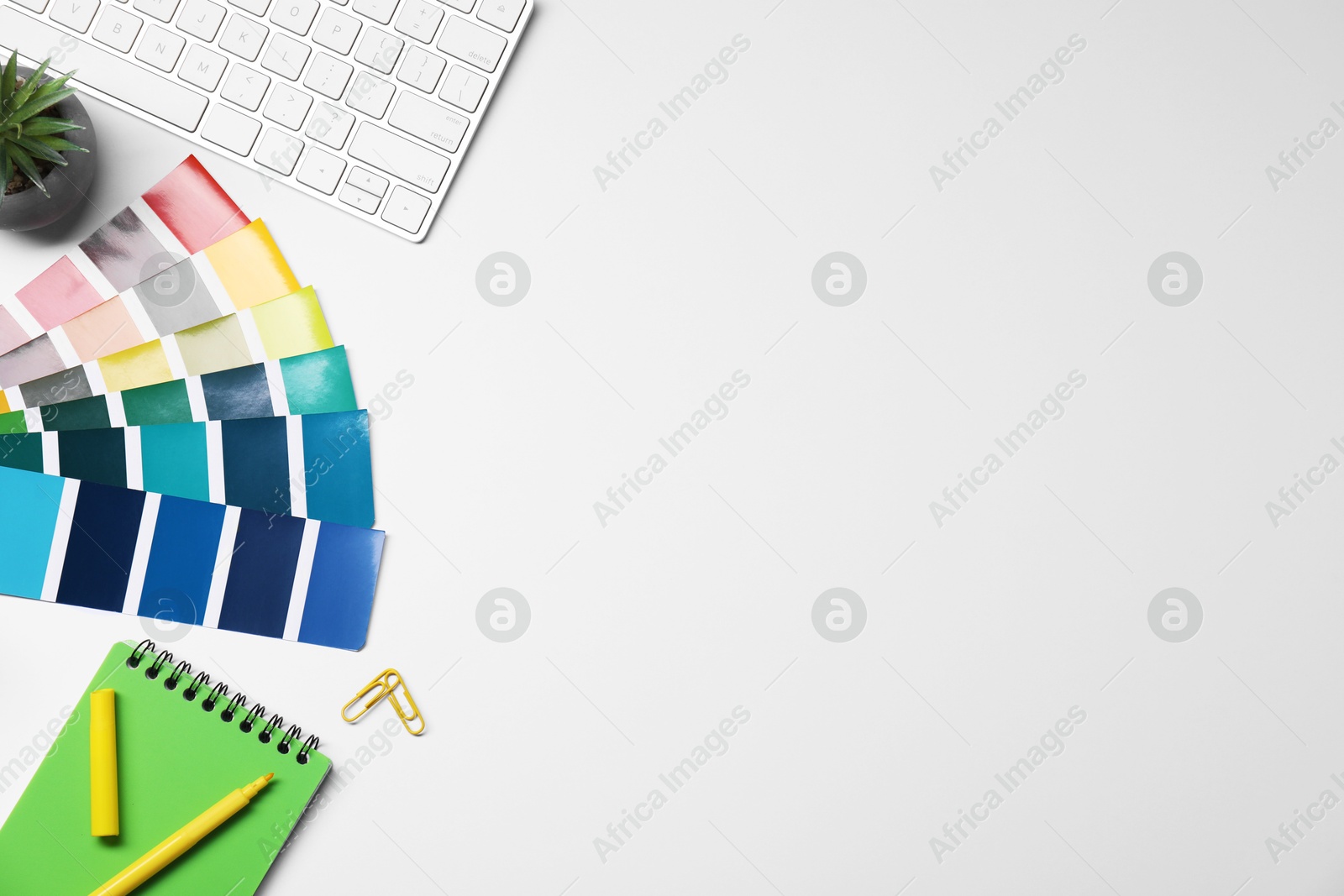 Photo of Designer's workplace with keyboard and stationery on light background, flat lay. Space for text