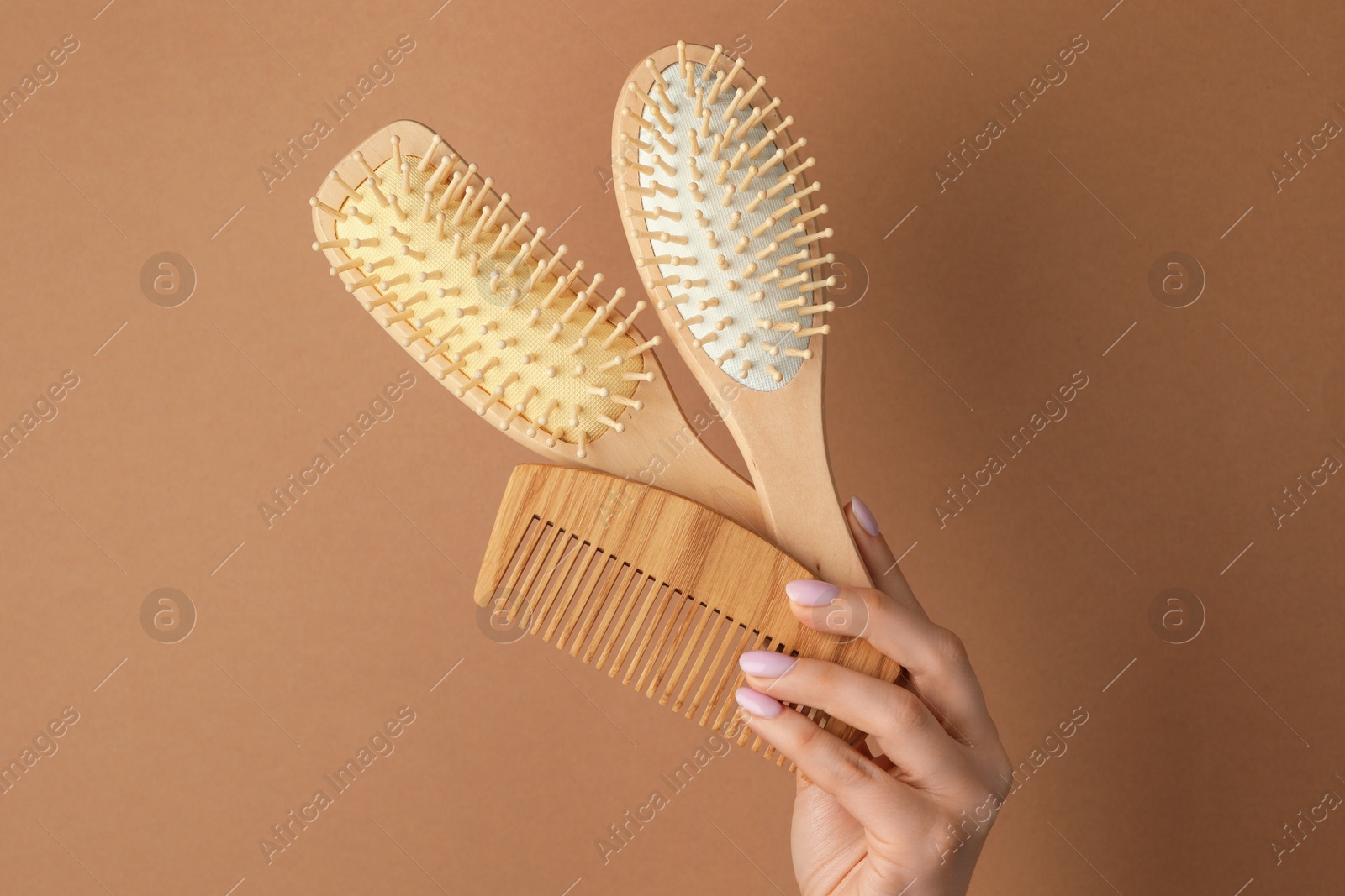 Photo of Woman with wooden brushes and comb on beige background, closeup