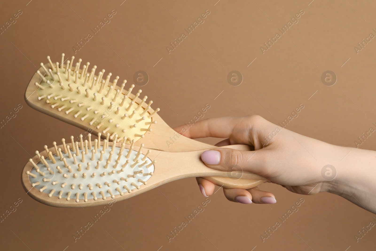 Photo of Woman with wooden brushes on beige background, closeup