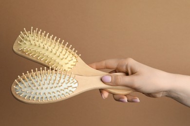 Photo of Woman with wooden brushes on beige background, closeup