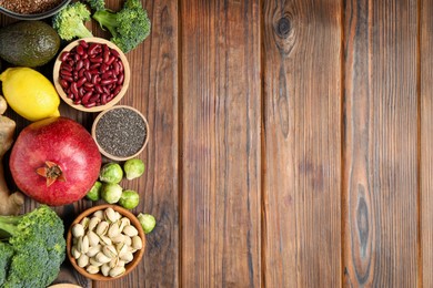 Photo of Different superfood products on wooden table, flat lay. Space for text