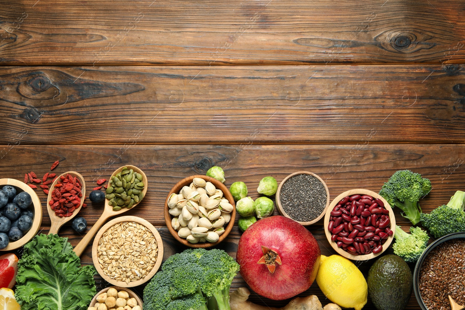 Photo of Different superfood products on wooden table, flat lay. Space for text