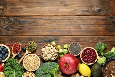 Photo of Different superfood products on wooden table, flat lay. Space for text