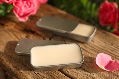 Photo of Natural solid perfume and pink roses on wood, closeup