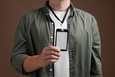 Photo of Man with blank badge on brown background, closeup