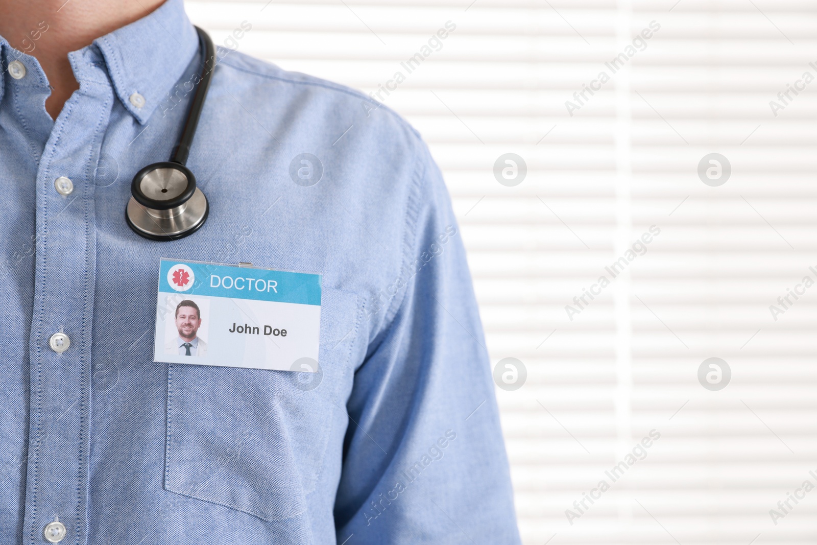 Photo of Doctor with badge in hospital, closeup. Space for text