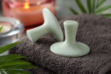 Photo of Spa stones, towel and green leaf on table, closeup