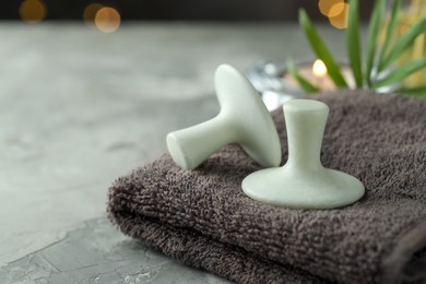 Photo of Spa stones and towel on grey table, closeup