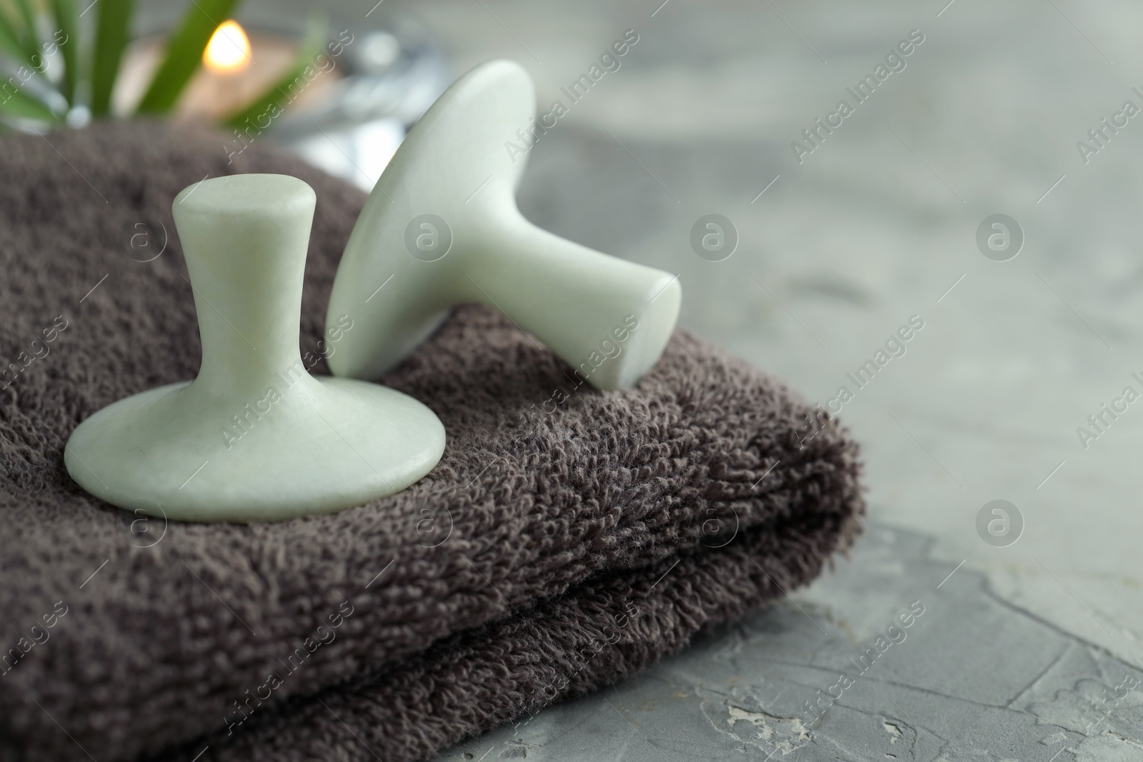 Photo of Spa stones and towel on grey table, closeup