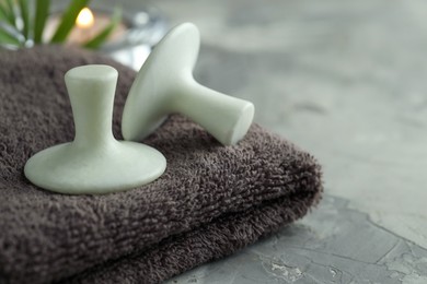 Photo of Spa stones and towel on grey table, closeup