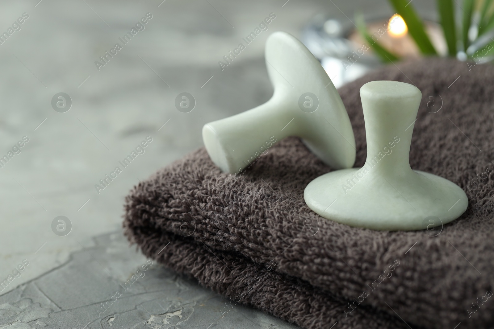 Photo of Spa stones and towel on grey table, closeup