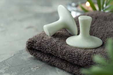 Photo of Spa stones and towel on grey table, closeup