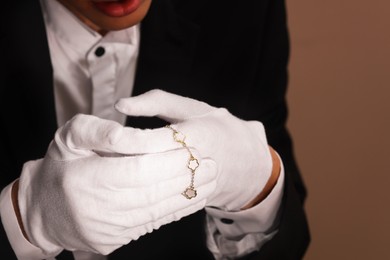 Photo of Appraiser with luxury jewelry on brown background, closeup