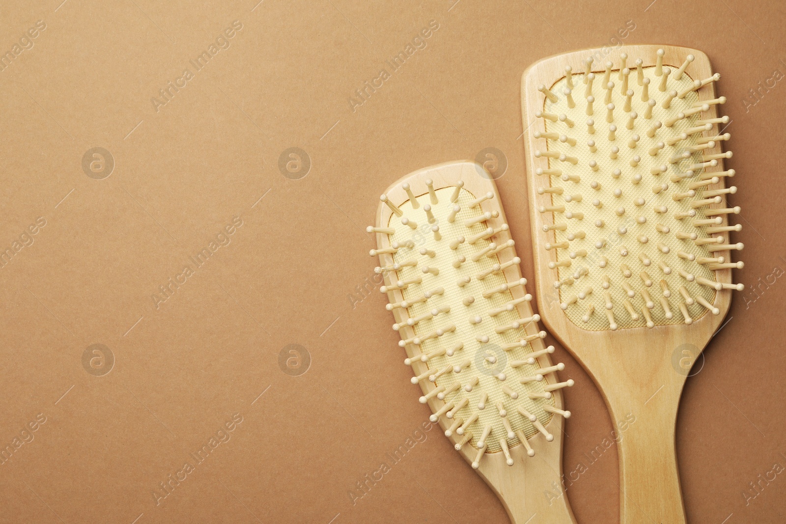 Photo of Wooden hair brushes on beige background, top view. Space for text