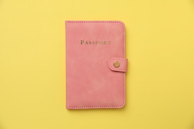 Photo of Passport in bright cover on yellow background, top view