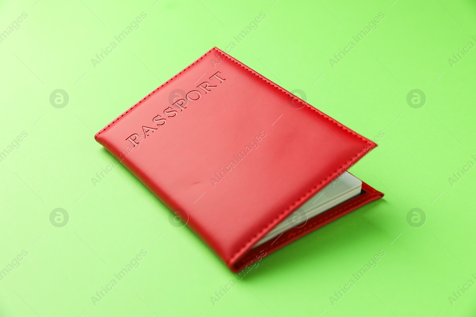 Photo of Passport in red cover on green background, closeup