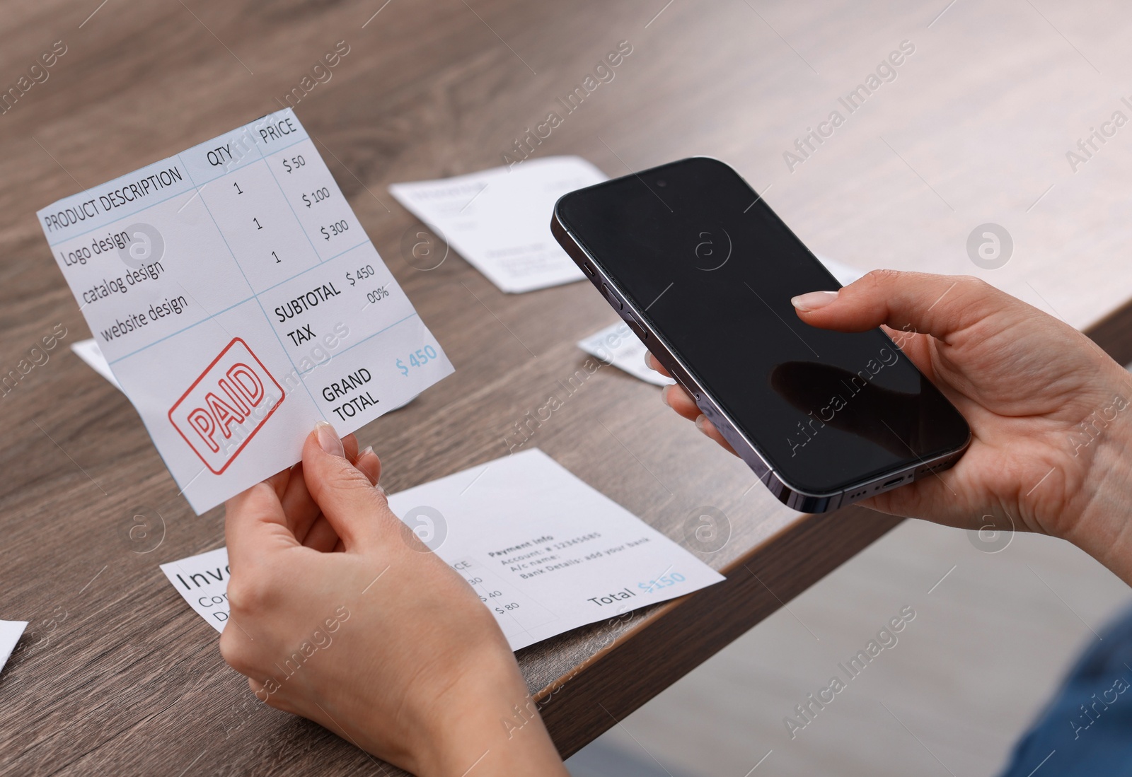 Photo of Paying bills. Woman with different invoices and phone at wooden table indoors, closeup