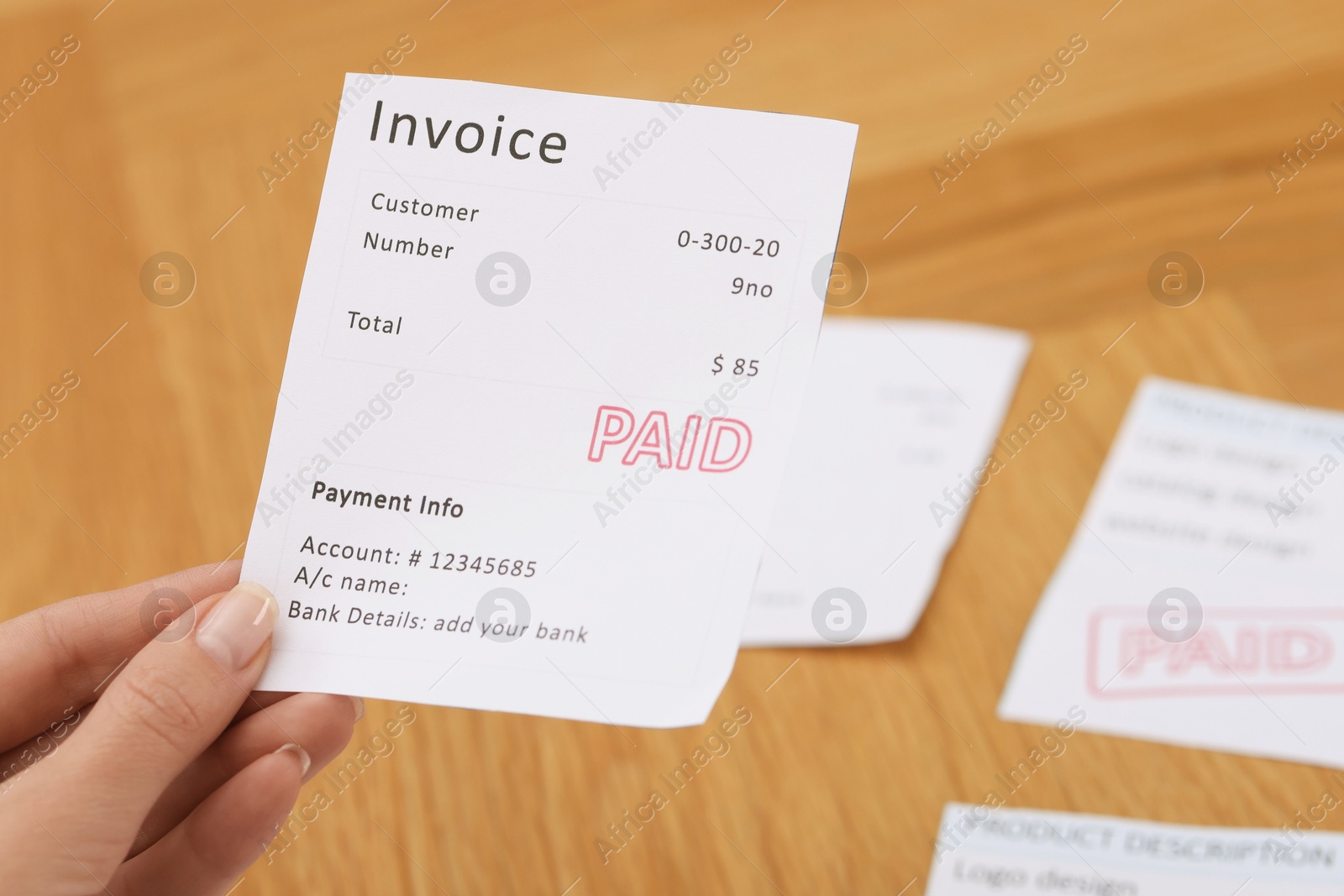 Photo of Paying bills. Woman with different invoices at wooden table indoors, closeup