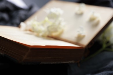 Photo of One open book on black blanket, closeup