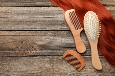 Photo of Brush, combs and lock of hair on wooden table, flat lay. Space for text